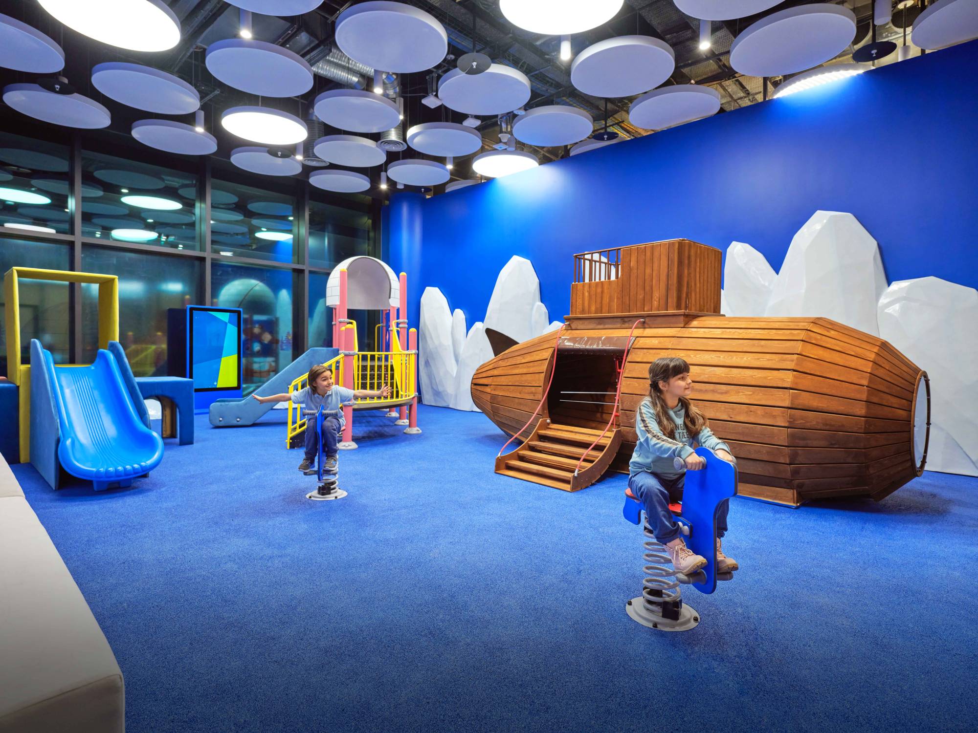 children riding to toy horses in the playground