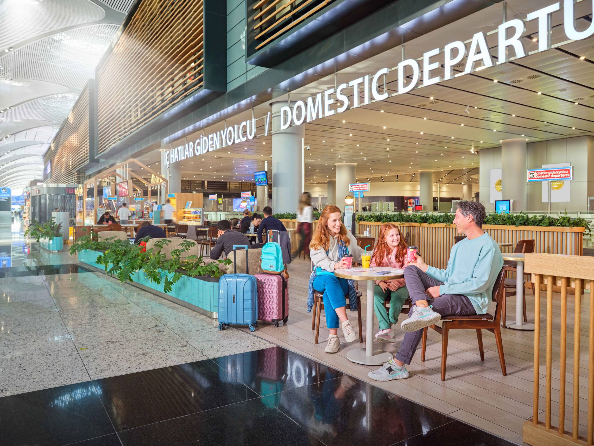 Family sitting in a cafe in the waiting area for domestic passengers