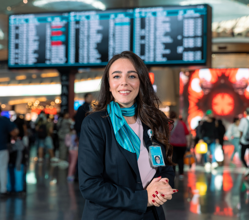 havalimanı bilgi ekranı önünde iga çalışanı