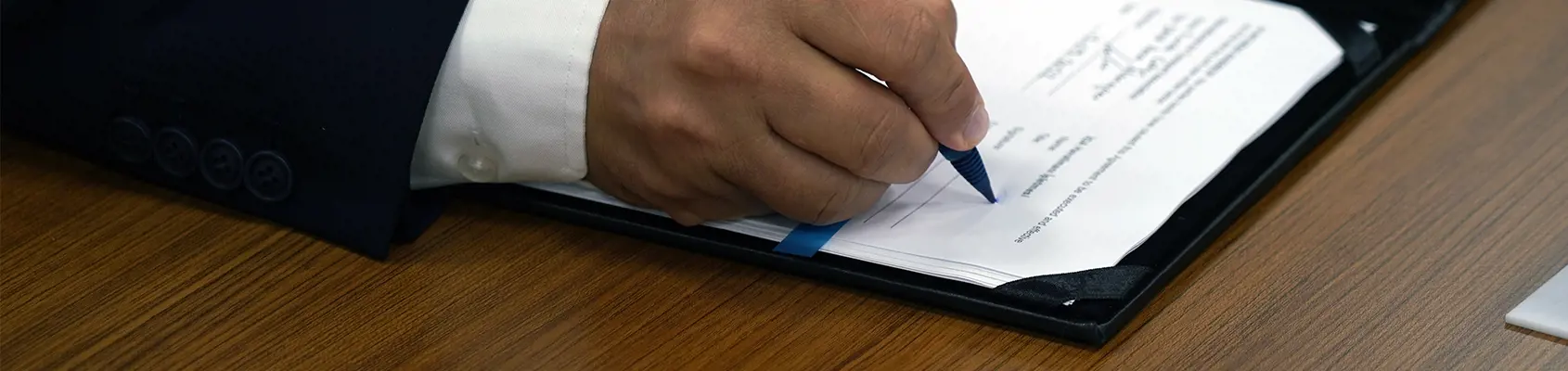 a hand signing a contract